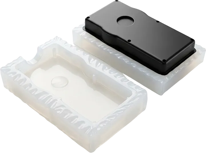 Dalgalı (zikzak) kesim detayına sahip, yarı saydam beyaz RTV2 silikon kalıp ve içinde üretilmiş siyah elektronik kutu prototipi.